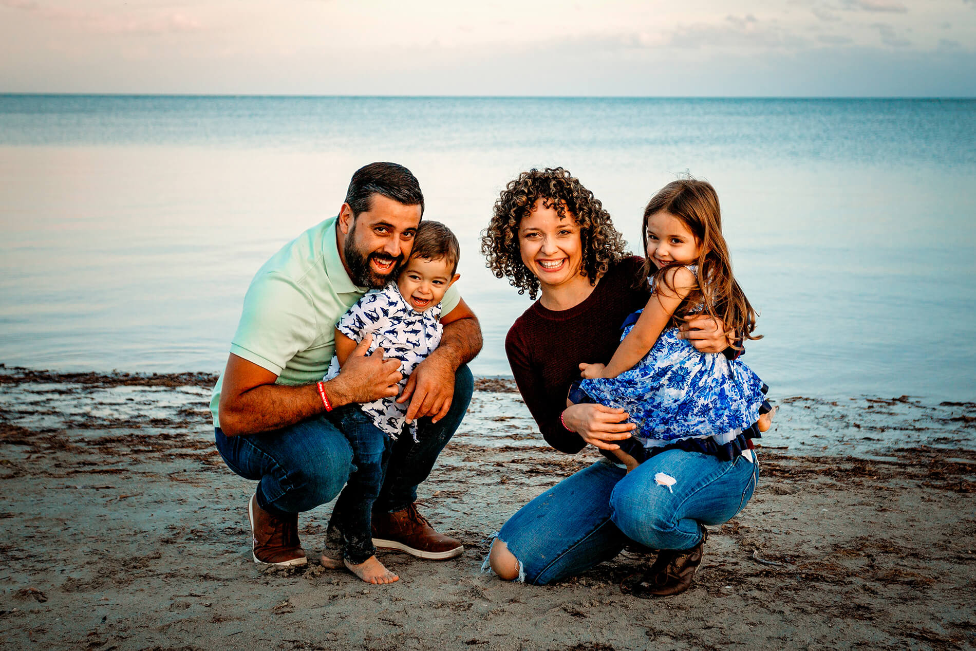 loving family posing in front of the shoreline